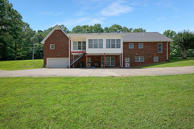 398 N Hummingbird Ln, Dickson, TN 37055 - back of property with driveway, brick siding, an attached garage, and a lawn