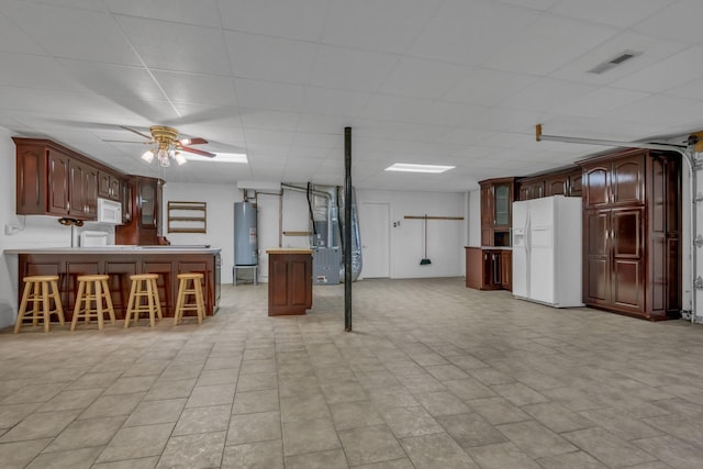 398 N Hummingbird Ln, Dickson, TN 37055 - kitchen featuring white appliances, a peninsula, a breakfast bar area, a ceiling fan, and water heater