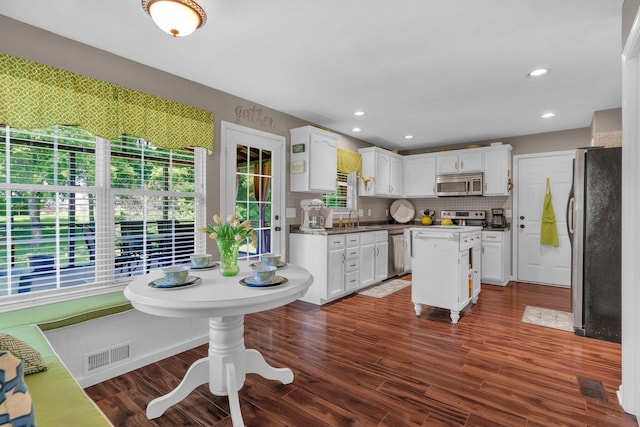 805 Tunewood Ct, Hermitage, TN 37076 - kitchen with stainless steel appliances, white cabinets, backsplash, dark wood finished floors, and a kitchen island