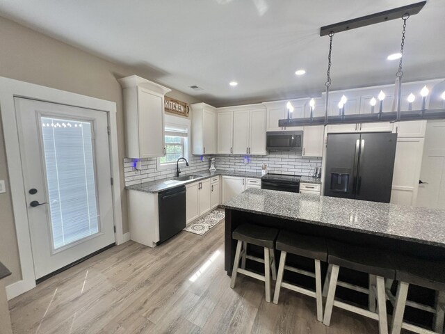 108 Chase Bend Rd, Estill Springs, TN 37330 - kitchen with black appliances, tasteful backsplash, light stone countertops, white cabinets, and light wood-style floors