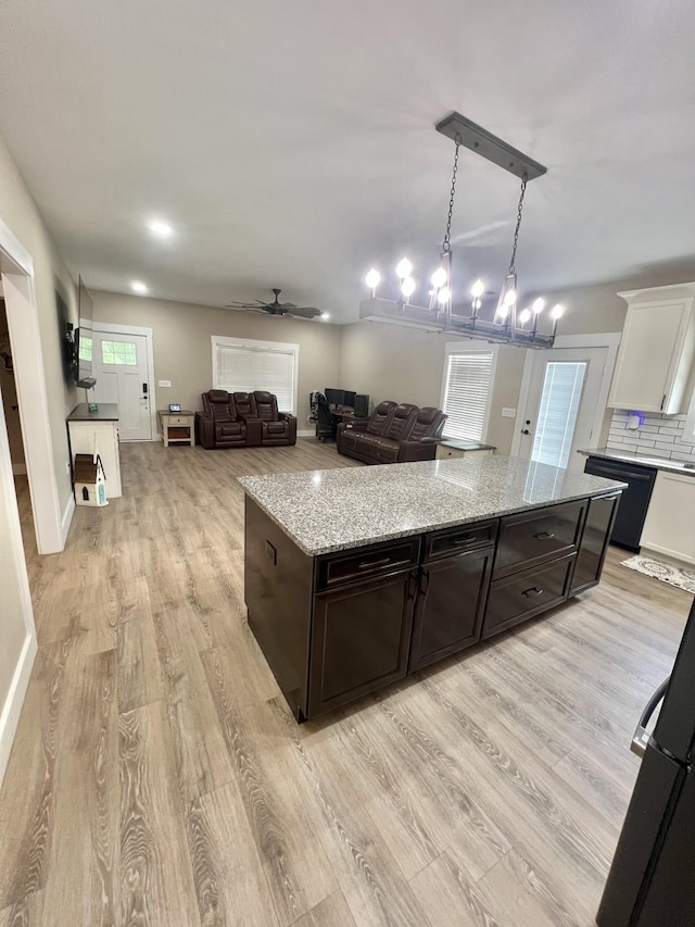 108 Chase Bend Rd, Estill Springs, TN 37330 - kitchen with light wood-style flooring, open floor plan, light stone counters, and dark brown cabinetry