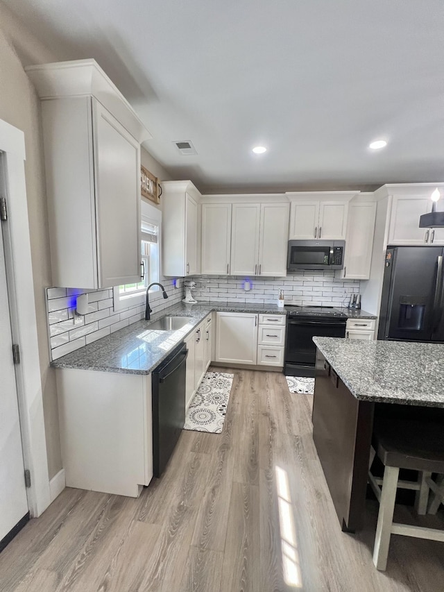 108 Chase Bend Rd, Estill Springs, TN 37330 - kitchen featuring black appliances, light stone countertops, white cabinets, and recessed lighting