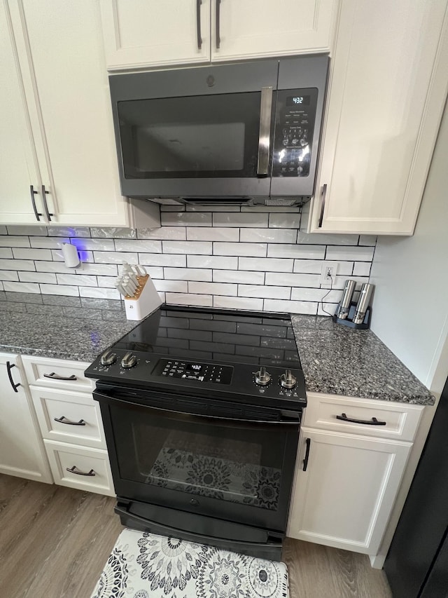 108 Chase Bend Rd, Estill Springs, TN 37330 - kitchen with black range with electric stovetop, wood finished floors, white cabinets, and backsplash