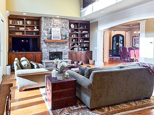 205 Nature Ridge Rd, Tullahoma, TN 37388 - living area with ornate columns, wood finished floors, a stone fireplace, built in features, and a towering ceiling