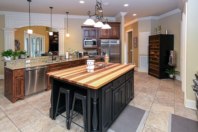 205 Nature Ridge Rd, Tullahoma, TN 37388 - kitchen with stainless steel appliances, butcher block counters, a kitchen island, arched walkways, and a peninsula