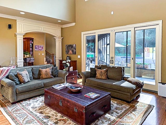 205 Nature Ridge Rd, Tullahoma, TN 37388 - living room with ornate columns, arched walkways, wood finished floors, stairs, and a towering ceiling