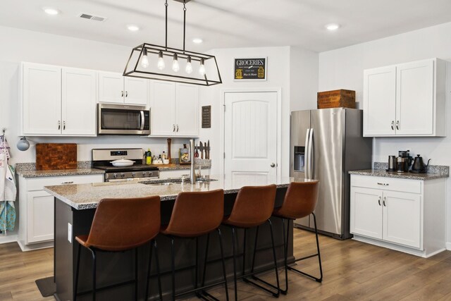 1006 Pepper Stone Dr, Lebanon, TN 37087 - kitchen featuring appliances with stainless steel finishes, dark wood-style floors, a center island with sink, white cabinets, and recessed lighting