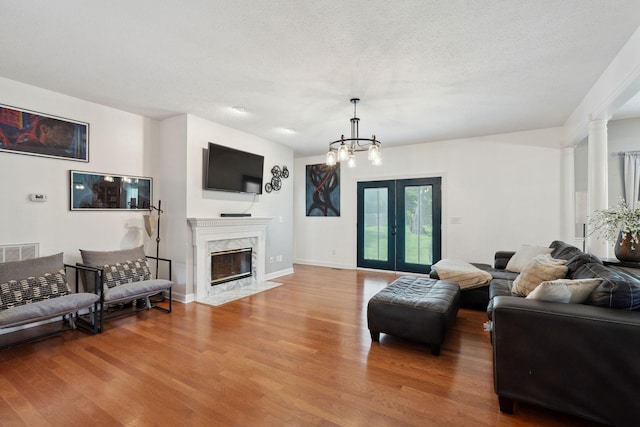 1908 Pointe Barton Dr, Lebanon, TN 37087 - living area with wood finished floors, a premium fireplace, a chandelier, a textured ceiling, and french doors