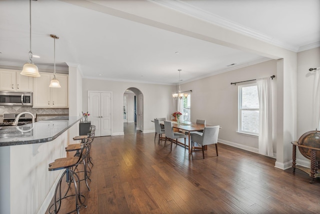 312 Rafferty Ct, Franklin, TN 37064 - dining room featuring arched walkways, dark wood-type flooring, crown molding, and a chandelier