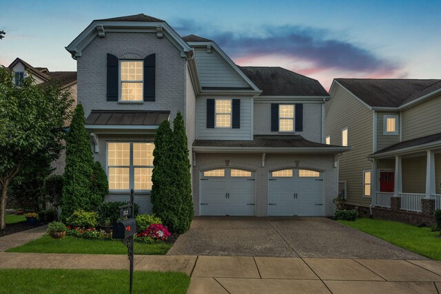 312 Rafferty Ct, Franklin, TN 37064 - view of front facade with brick siding, an attached garage, driveway, and a standing seam roof