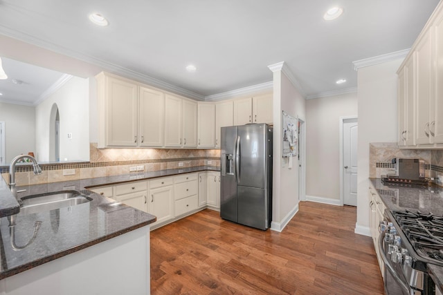 312 Rafferty Ct, Franklin, TN 37064 - kitchen featuring appliances with stainless steel finishes, dark stone countertops, tasteful backsplash, recessed lighting, and wood finished floors