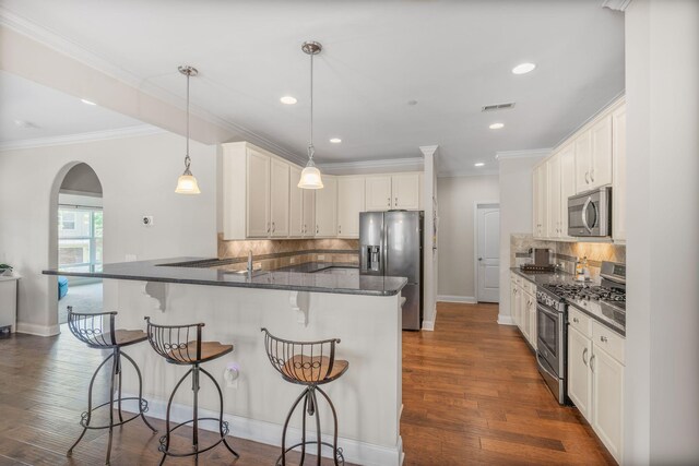 312 Rafferty Ct, Franklin, TN 37064 - kitchen with stainless steel appliances, arched walkways, a peninsula, tasteful backsplash, and recessed lighting