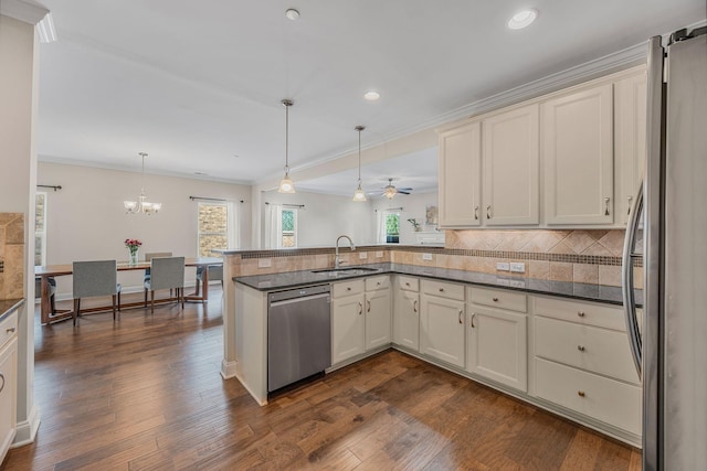 312 Rafferty Ct, Franklin, TN 37064 - kitchen featuring stainless steel appliances, a peninsula, crown molding, tasteful backsplash, and dark wood-style flooring