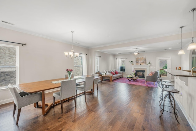 312 Rafferty Ct, Franklin, TN 37064 - dining area featuring dark wood-style floors, a fireplace, a chandelier, ornamental molding, and ceiling fan