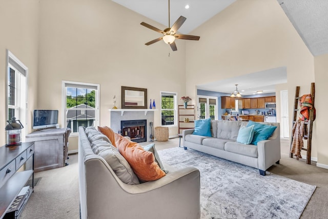 3299 Twelve Oaks Blvd, Clarksville, TN 37042 - living room with light carpet, high vaulted ceiling, a ceiling fan, healthy amount of natural light, and a fireplace with raised hearth