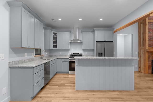 414 Ault Rd, Signal Mountain, TN 37377 - kitchen with wall chimney range hood, stainless steel appliances, gray cabinetry, a kitchen island, and light wood-style floors