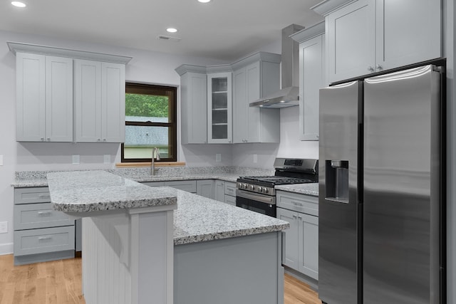 414 Ault Rd, Signal Mountain, TN 37377 - kitchen featuring stainless steel appliances, wall chimney range hood, gray cabinetry, light stone counters, and light wood-style flooring