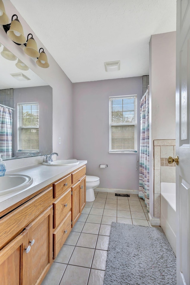 5601 Murphywood Xing, Antioch, TN 37013 - bathroom with healthy amount of natural light, double vanity, tile patterned floors, a bath, and a textured ceiling