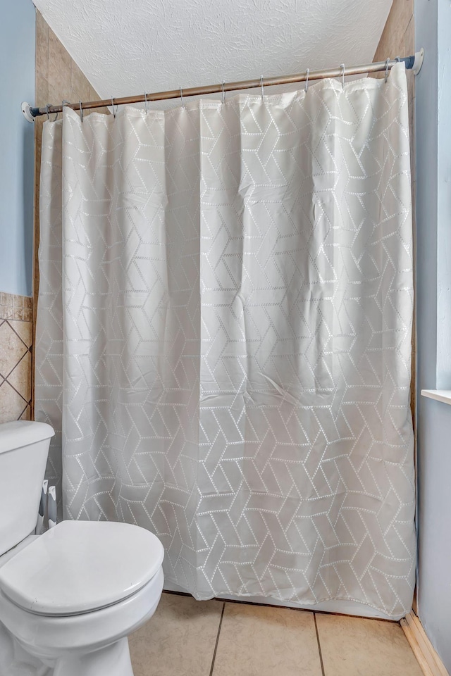 5601 Murphywood Xing, Antioch, TN 37013 - full bathroom featuring a textured ceiling, tile walls, tile patterned flooring, and a shower with curtain