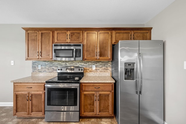 141 Bob White Trl, Oak Grove, KY 42262 - kitchen with appliances with stainless steel finishes, brown cabinetry, backsplash, and light stone counters