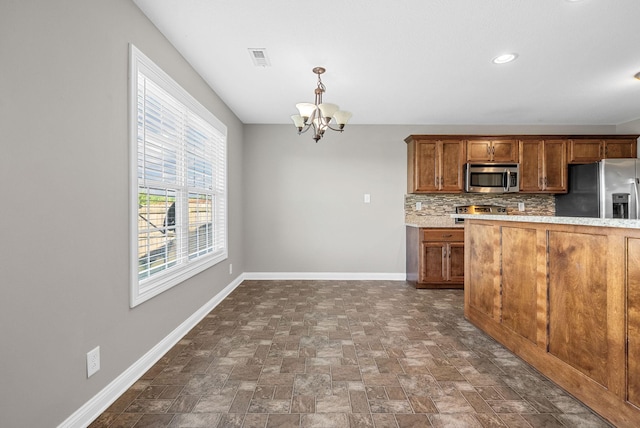 141 Bob White Trl, Oak Grove, KY 42262 - kitchen with appliances with stainless steel finishes, brown cabinets, a chandelier, decorative backsplash, and hanging light fixtures