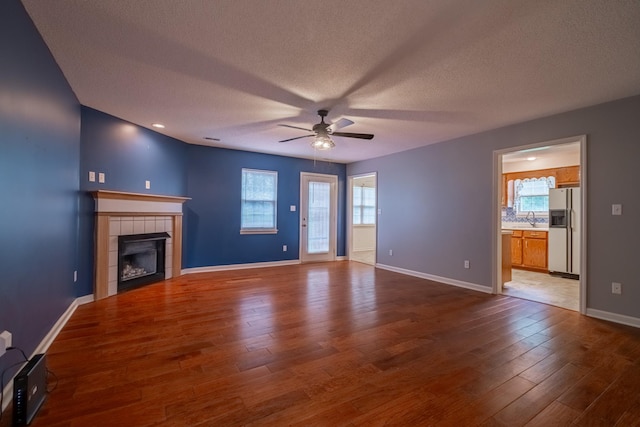 218 Susie Dr, Winchester, TN 37398 - unfurnished living room with a ceiling fan, a tile fireplace, wood finished floors, and a textured ceiling