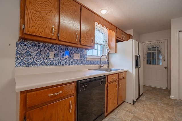 218 Susie Dr, Winchester, TN 37398 - kitchen with black dishwasher, brown cabinets, light countertops, white refrigerator with ice dispenser, and backsplash