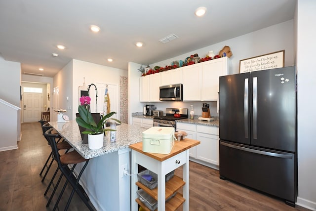 7050 Scotlyn Way, White House, TN 37188 - kitchen featuring stainless steel appliances, white cabinetry, a kitchen bar, dark wood-style floors, and recessed lighting