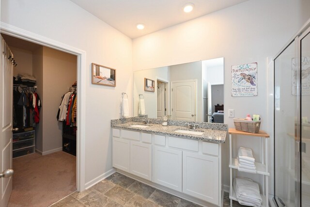7050 Scotlyn Way, White House, TN 37188 - bathroom with double vanity, a shower stall, a spacious closet, and recessed lighting