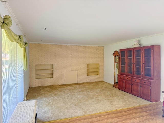 115 Horseshoe St, Pulaski, TN 38478 - spare room featuring crown molding, brick wall, light carpet, and light wood finished floors