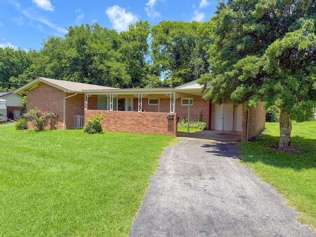115 Horseshoe St, Pulaski, TN 38478 - ranch-style home featuring a front yard, driveway, brick siding, and a carport