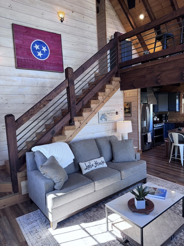 139 E Swan Ridge Rd, Hilham, TN 38568 - living room featuring wooden walls, wood finished floors, a high ceiling, stairs, and beam ceiling