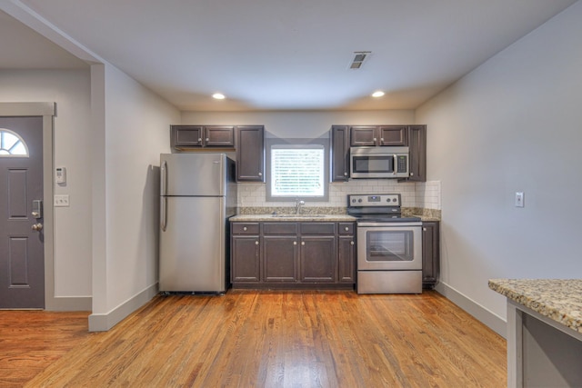 1205 Dr Db Todd Jr Blvd, Nashville, TN 37208 - kitchen with appliances with stainless steel finishes, decorative backsplash, light wood-type flooring, and recessed lighting