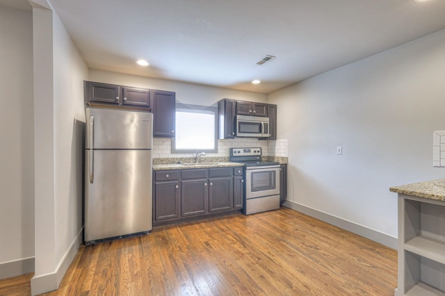 1205 Dr Db Todd Jr Blvd, Nashville, TN 37208 - kitchen with appliances with stainless steel finishes, backsplash, dark wood-style floors, light stone countertops, and recessed lighting