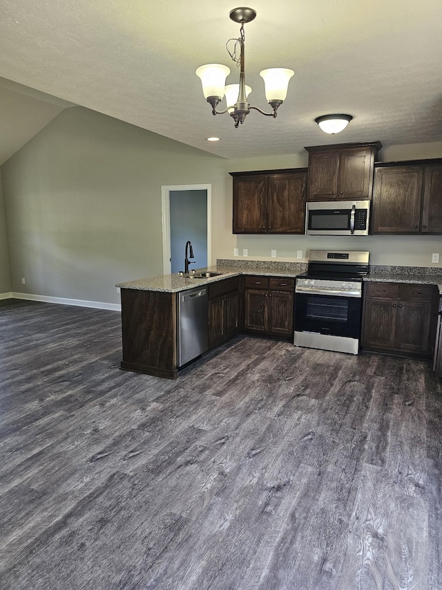 4070 Hartsville Rd, Lafayette, TN 37083 - kitchen featuring stainless steel appliances, dark brown cabinets, a peninsula, dark wood-style flooring, and lofted ceiling