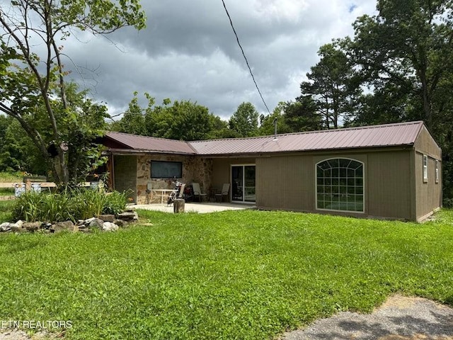 329 Wheeler Ln, Jamestown, TN 38556 - back of house featuring a metal roof, a lawn, and a patio area
