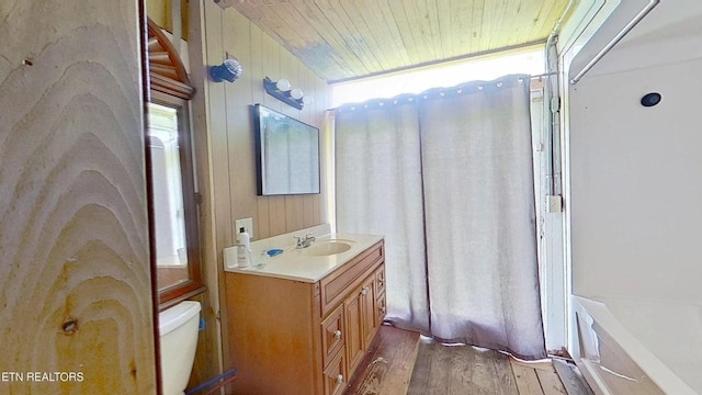 329 Wheeler Ln, Jamestown, TN 38556 - full bath featuring wood finished floors, vanity, wood ceiling, wood walls, and a tub to relax in