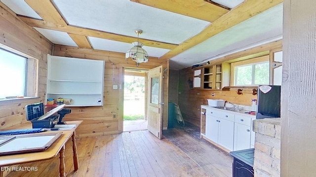 329 Wheeler Ln, Jamestown, TN 38556 - kitchen featuring wooden walls, white cabinets, light wood-style floors, pendant lighting, and beam ceiling