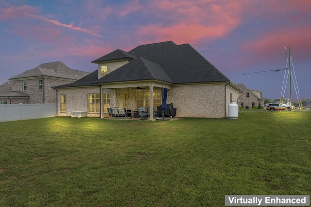 1446 Millstone Creek Rd, Lascassas, TN 37085 - back of property at dusk with ceiling fan, an outdoor hangout area, a patio, a shingled roof, and brick siding