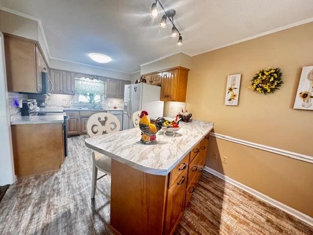 570 Gaines Cir, Estill Springs, TN 37330 - kitchen featuring white refrigerator with ice dispenser, range with electric cooktop, stainless steel microwave, a peninsula, and a breakfast bar