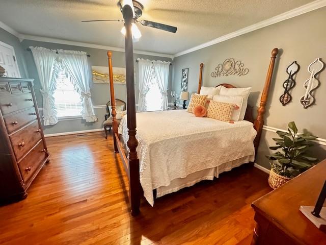570 Gaines Cir, Estill Springs, TN 37330 - bedroom featuring wood finished floors, ornamental molding, multiple windows, ceiling fan, and a textured ceiling