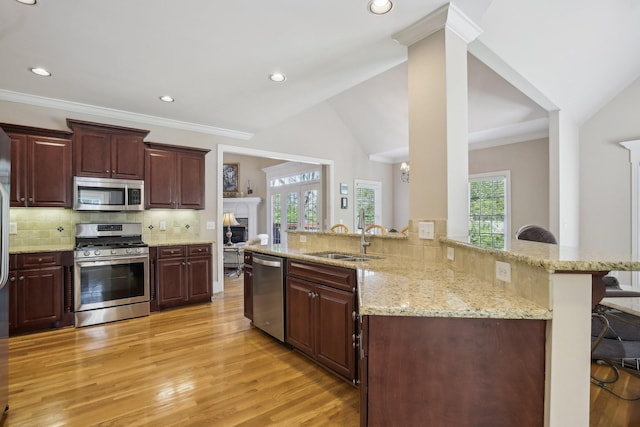 511 Derby Downs, Lebanon, TN 37087 - kitchen featuring appliances with stainless steel finishes, light wood-style floors, a fireplace, decorative backsplash, and lofted ceiling