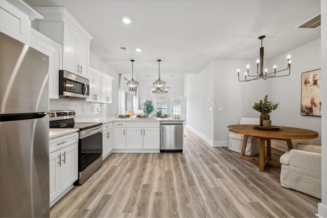 541 Tulip Springs Rd, Hermitage, TN 37076 - kitchen with appliances with stainless steel finishes, a chandelier, a peninsula, light countertops, and white cabinetry