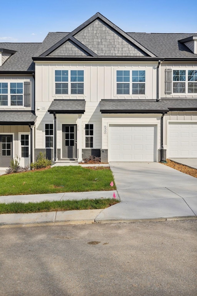 541 Tulip Springs Rd, Hermitage, TN 37076 - view of property with board and batten siding, an attached garage, driveway, a front lawn, and a shingled roof