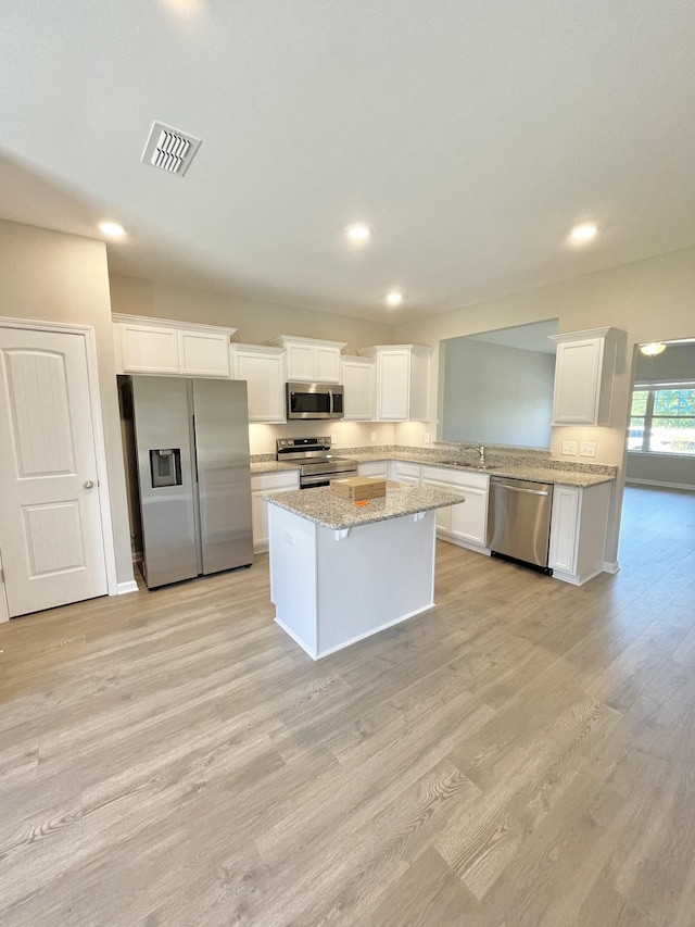 404 Wren Way, Spring Hill, TN 37174 - kitchen featuring stainless steel appliances, light wood-style flooring, a center island, white cabinets, and recessed lighting