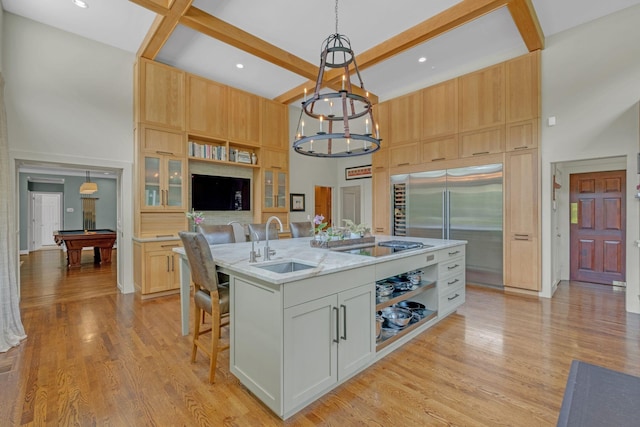 111 Hardingwoods Pl, Nashville, TN 37205 - kitchen featuring a towering ceiling, a center island with sink, stainless steel built in fridge, light wood finished floors, and a chandelier