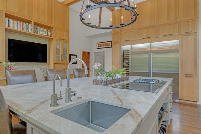 111 Hardingwoods Pl, Nashville, TN 37205 - kitchen with a chandelier, stainless steel built in fridge, light stone counters, black stovetop, and light wood-type flooring