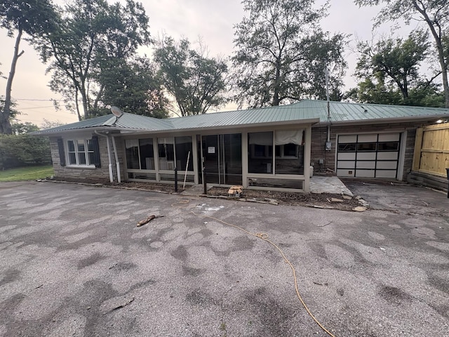 8827 Horton Hwy, College Grove, TN 37046 - ranch-style home featuring a garage, a metal roof, asphalt driveway, and a sunroom