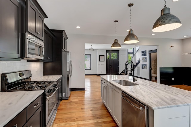 2136 Buena Vista Pike Unit B, Nashville, TN 37218 - kitchen with appliances with stainless steel finishes, a center island with sink, light wood-type flooring, backsplash, and a ceiling fan