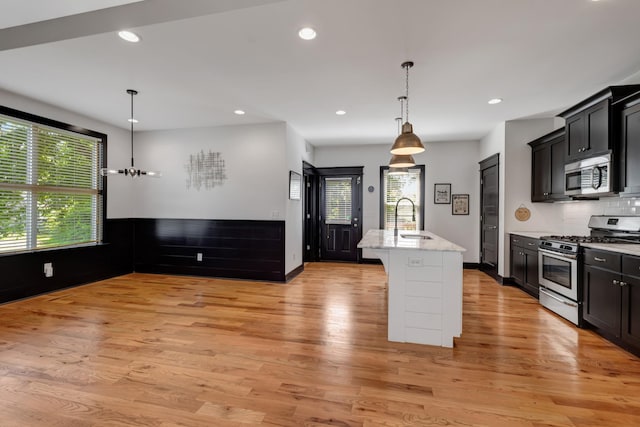 2136 Buena Vista Pike Unit B, Nashville, TN 37218 - kitchen with stainless steel appliances, light wood-type flooring, a center island with sink, recessed lighting, and decorative backsplash